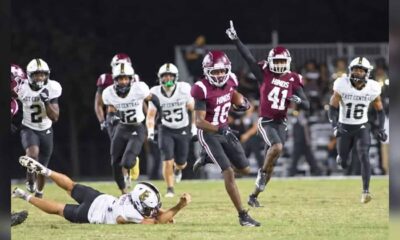 Hinds CC football player running with the ball while defenders chase during a game, celebrating a touchdown. — 52-28