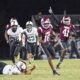 Hinds CC football player running with the ball while defenders chase during a game, celebrating a touchdown. — 52-28
