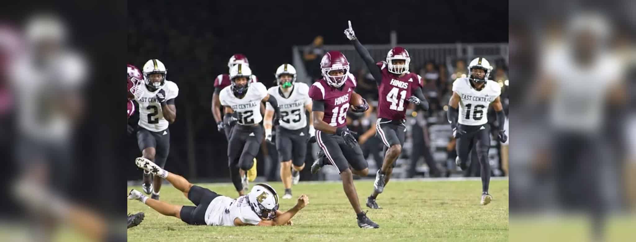 Hinds CC football player running with the ball while defenders chase during a game, celebrating a touchdown. — 52-28