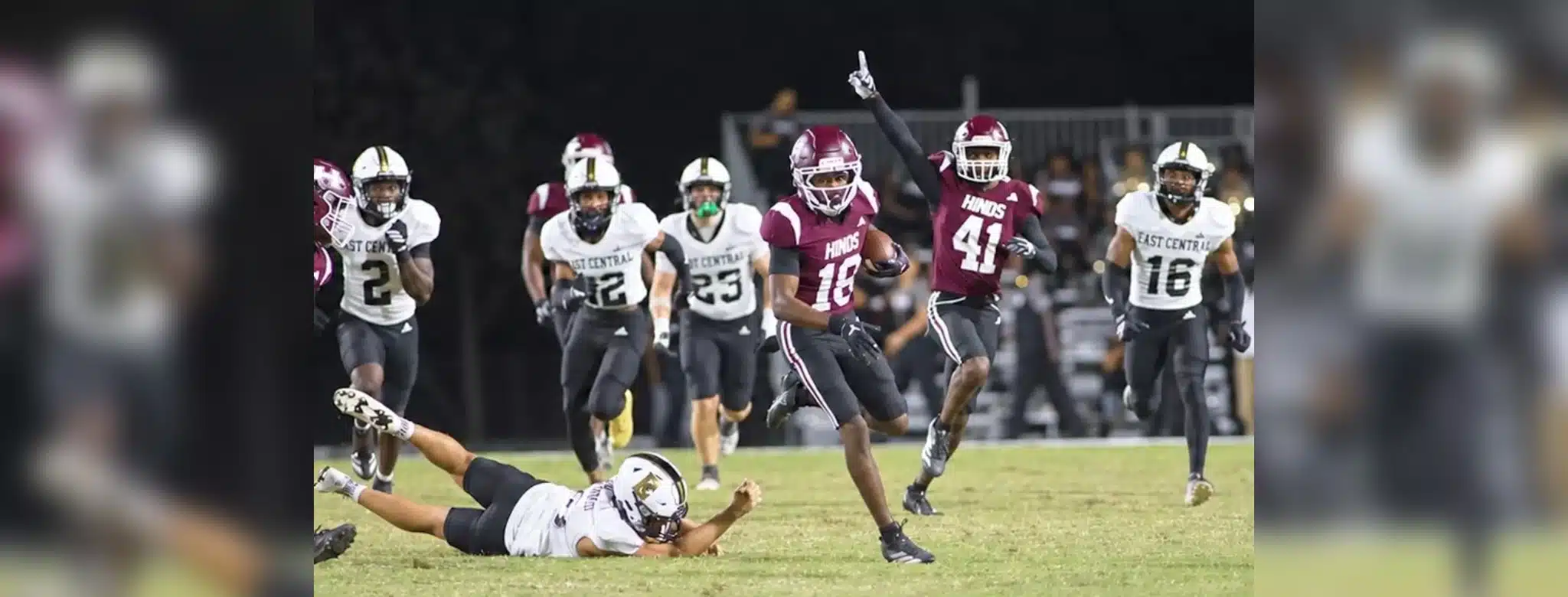 Hinds CC football player running with the ball while defenders chase during a game, celebrating a touchdown. — 52-28