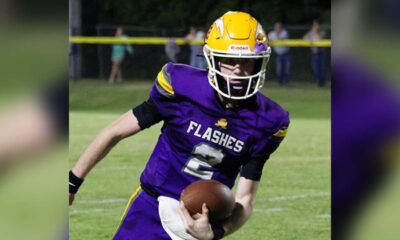 A St. Aloysius quarterback in a purple jersey runs with the football during a — Flashes defeated Manchester Academy 49-14