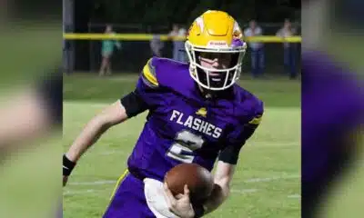 A St. Aloysius quarterback in a purple jersey runs with the football during a — Flashes defeated Manchester Academy 49-14