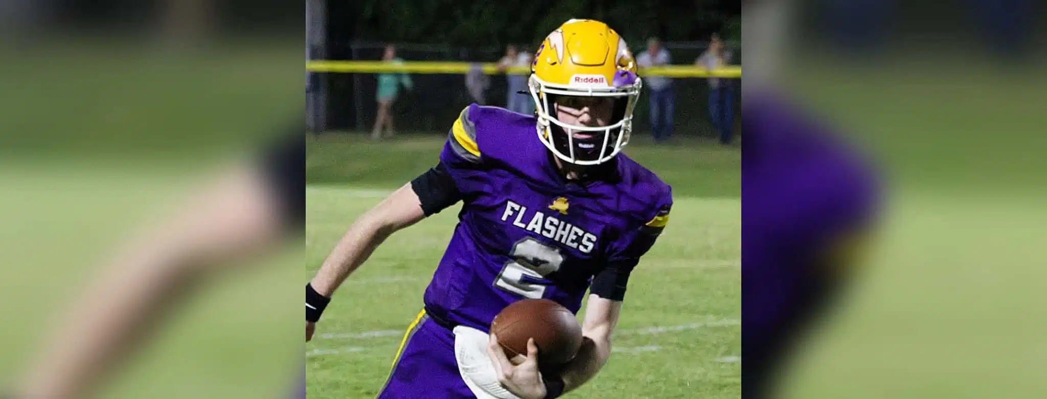 A St. Aloysius quarterback in a purple jersey runs with the football during a — Flashes defeated Manchester Academy 49-14