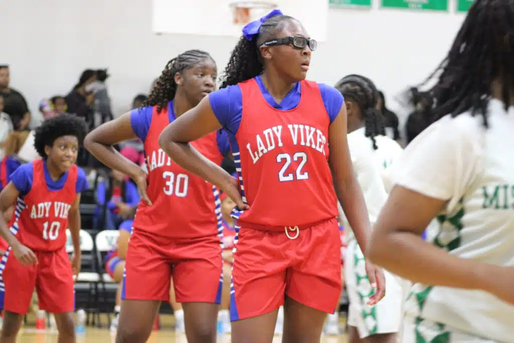 Warren Central Junior girls basketball players in red Lady Vikes uniforms during a game, with number 22 in the foreground.