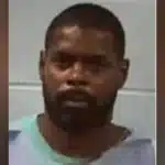 Roosevelt Harris in a gray prison outfit, appearing solemn in a mugshot.