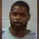 Roosevelt Harris in a gray prison outfit, appearing solemn in a mugshot.