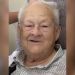 Elderly man with gray hair smiling warmly at the camera. — William