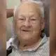 Elderly man with gray hair smiling warmly at the camera. — William