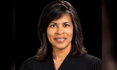 Judge Vicki Barnes in judicial robes, smiling against a dark background.