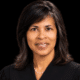 Judge Vicki Barnes in judicial robes, smiling against a dark background.