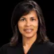 Judge Vicki Barnes in judicial robes, smiling against a dark background.