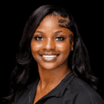 Ty’Kerria Henderson, a family medicine provider, smiles confidently in a professional setting.