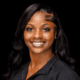 Ty’Kerria Henderson, a family medicine provider, smiles confidently in a professional setting.