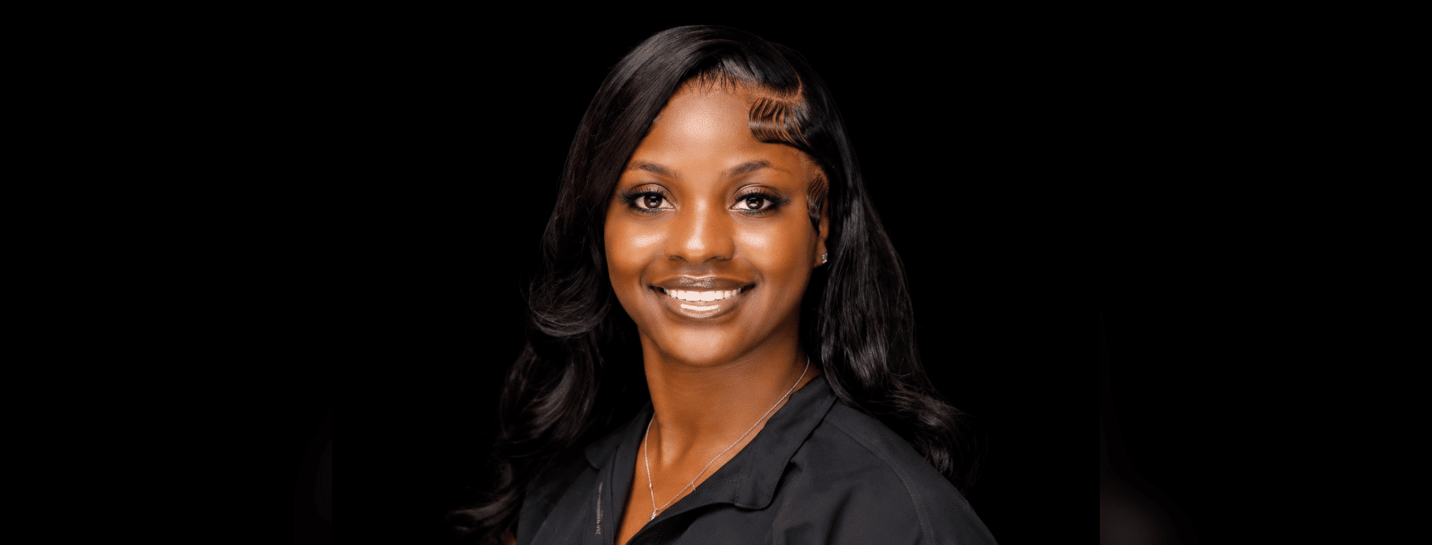 Ty’Kerria Henderson, a family medicine provider, smiles confidently in a professional setting.