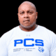 William Prince, a former athlete, wearing a white shirt with PCS logo, looking serious and confident.