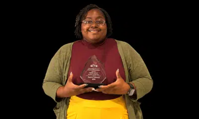 Patrice Johnson proudly holds her Mississippi Middle School Teacher of the Year award, smiling in a professional setting.
