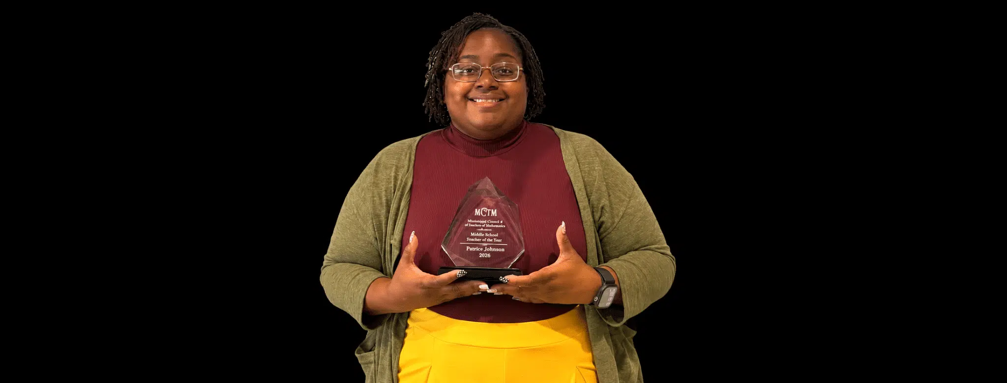 Patrice Johnson proudly holds her Mississippi Middle School Teacher of the Year award, smiling in a professional setting.