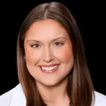Portrait of a smiling woman with long brown hair, wearing a white coat. — Madeleine Gaul