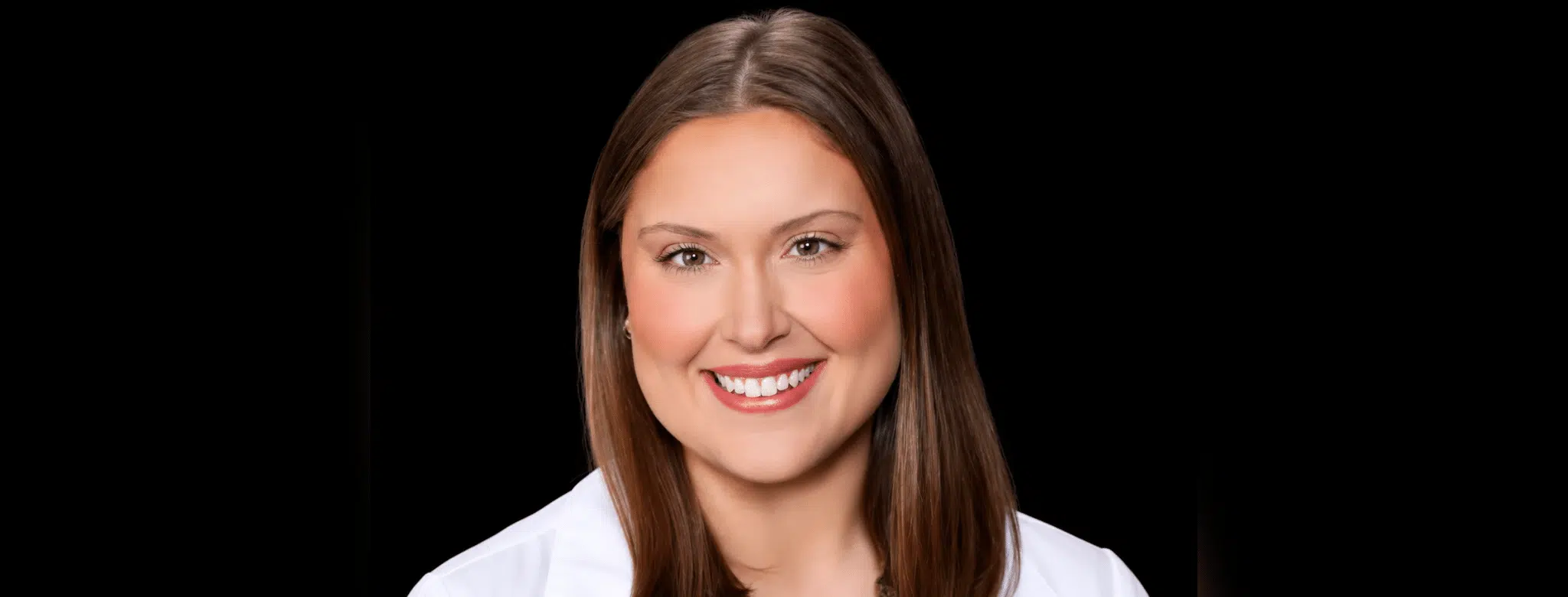 Portrait of a smiling woman with long brown hair, wearing a white coat. — Madeleine Gaul