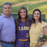 Megan Theriot in a softball uniform poses with her parents on t — Megan Theriot selected to play in the MAIS All-Star Game