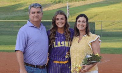 Megan Theriot in a softball uniform poses with her parents on t — Megan Theriot selected to play in the MAIS All-Star Game