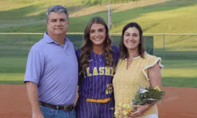 Megan Theriot in a softball uniform poses with her parents on t — Megan Theriot selected to play in the MAIS All-Star Game