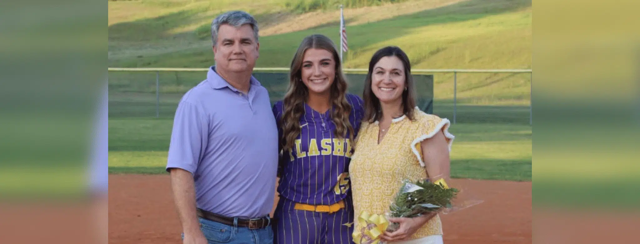 Megan Theriot in a softball uniform poses with her parents on t — Megan Theriot selected to play in the MAIS All-Star Game