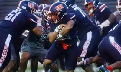 Jackson State player running with the ball during a football game against Alabama A&M, showcasing team spirit and — 31-28
