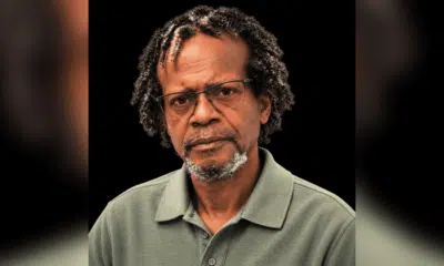 A serious-looking man with glasses and curly hair, wearing a green polo shirt. — Leroy Newton