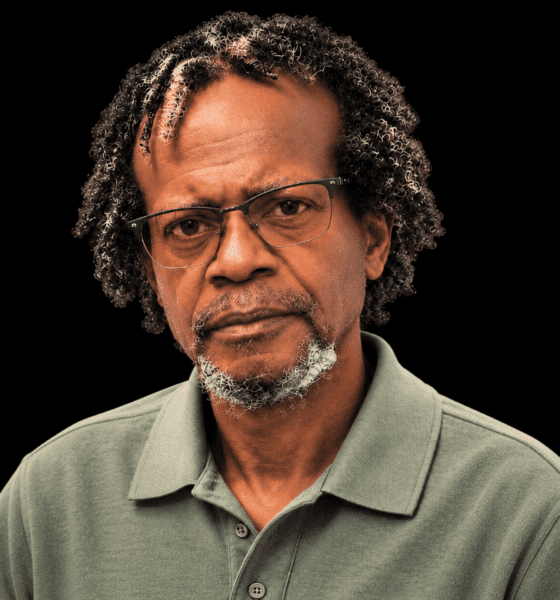 A serious-looking man with glasses and curly hair, wearing a green polo shirt. — Leroy Newton