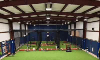 Interior view of a new indoor training facility with batting cages and turf flooring for student-athletes.