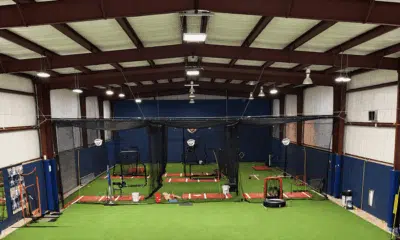 Interior view of a new indoor training facility with batting cages and turf flooring for student-athletes.