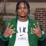 Wallyss Curry, a Vicksburg High School linebacker, shows four fingers while wearing a green an — Wallyss Curry 100 tackles
