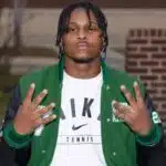 Wallyss Curry, a Vicksburg High School linebacker, shows four fingers while wearing a green an — Wallyss Curry 100 tackles