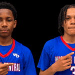 Gayvin Turner and Mason Truly in blue Warren Central basketball jerseys, pointing toward their uniforms.