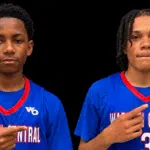Gayvin Turner and Mason Truly in blue Warren Central basketball jerseys, pointing toward their uniforms.