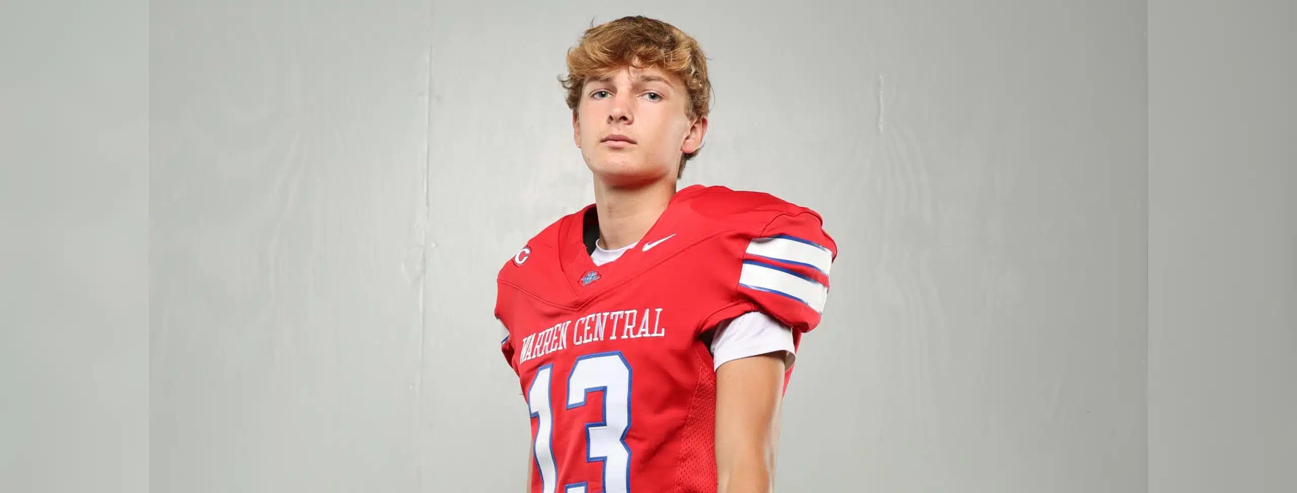 Warren Central High School kicker Nick Lee in a red football uniform, posing confidently against a plain background.