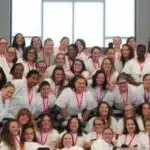 Group photo of 39 women inmates in white shirts celebrating graduation from a rehabilitation program.