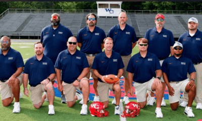 Warren Central football coaches pose on the field with helmets as the Vikings playoff season continues.
