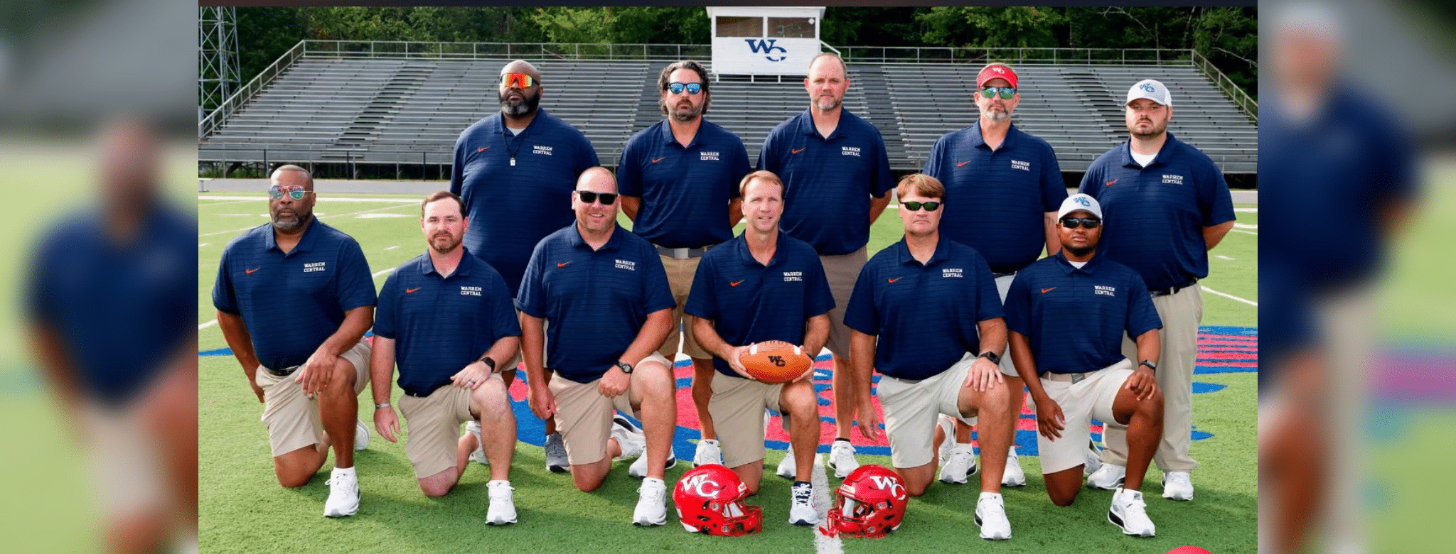 Warren Central football coaches pose on the field with helmets as the Vikings playoff season continues.