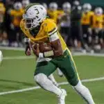 Belhaven football player running with the ball during a game against NC Wesleyan.