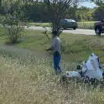 A Warren County Sheriff’s deputy injured in motorcycle crash, with responders and debris visible in the background.