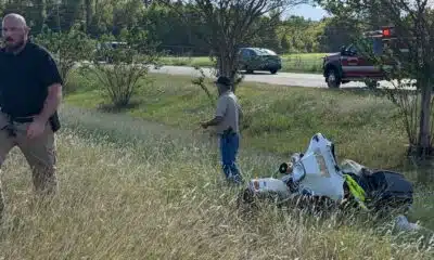 A Warren County Sheriff’s deputy injured in motorcycle crash, with responders and debris visible in the background.