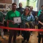 A group of people at a ribbon-cutting ceremony for Sojoz Treasures in Vicksburg.