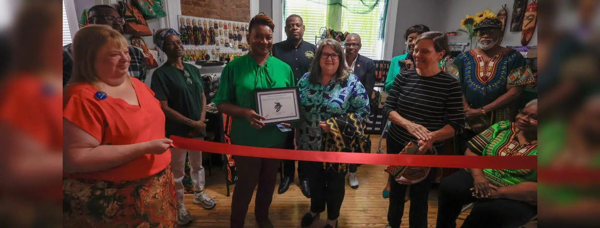 A group of people at a ribbon-cutting ceremony for Sojoz Treasures in Vicksburg.