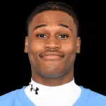 Royale Shelvy, a football player, smiles confidently in his team uniform.