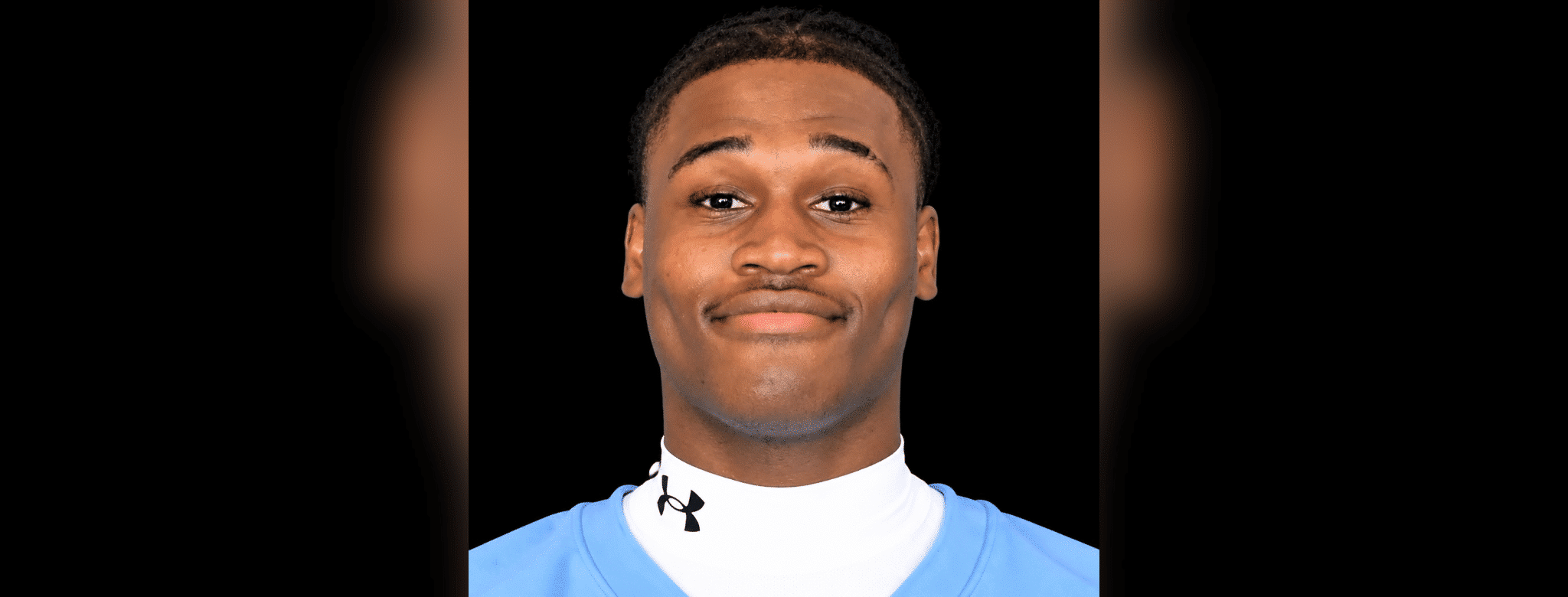 Royale Shelvy, a football player, smiles confidently in his team uniform.