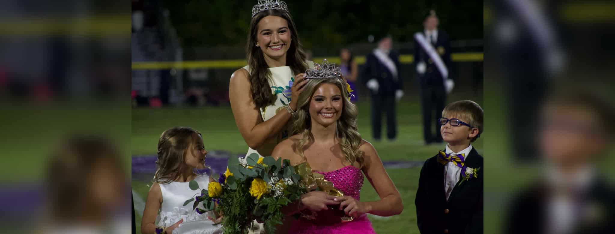 Hendrix Eldridge crowned homecoming queen wearing a pink dress and tiara, with a girl — Hendrix Eldridge Homecoming queen