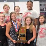 Warren Central girls' swim team celebrating with a trophy after finishing as state runner-up.