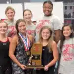 Warren Central girls' swim team celebrating with a trophy after finishing as state runner-up.